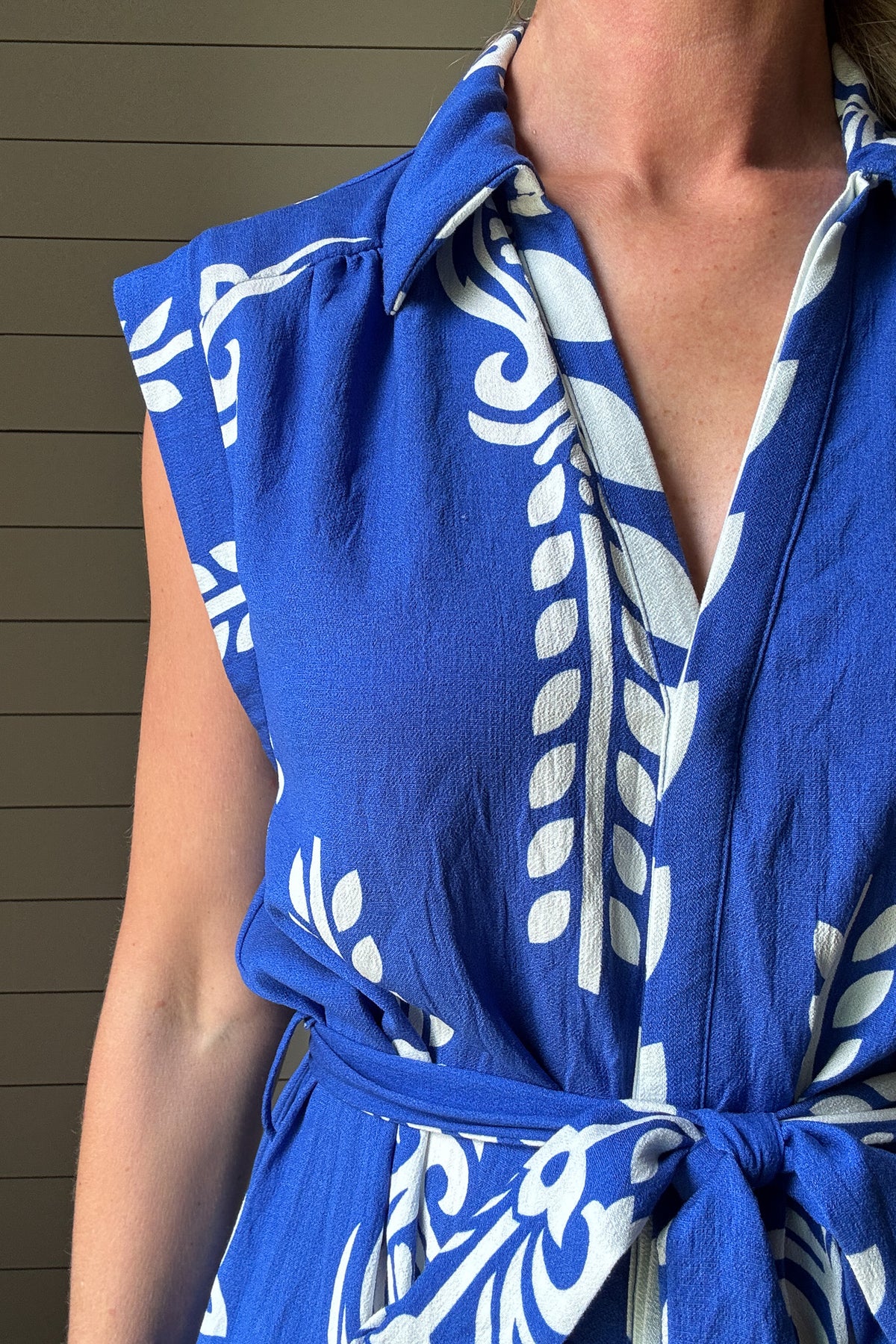 This striking blue and white midi dress brings effortless vacation vibes to your everyday. Designed with a flattering button-front and soft cap sleeves, the standout print and subtle structure make it an easy favorite. The fabric-covered buttons add a polished touch, while the adjustable tie belt defines the waist without feeling fussy. Made from rayon blend, it's unlined but not sheer—light enough for warm days with full coverage you can count on. Bold in detail and easy to wear, it’s perfect for brunch, b