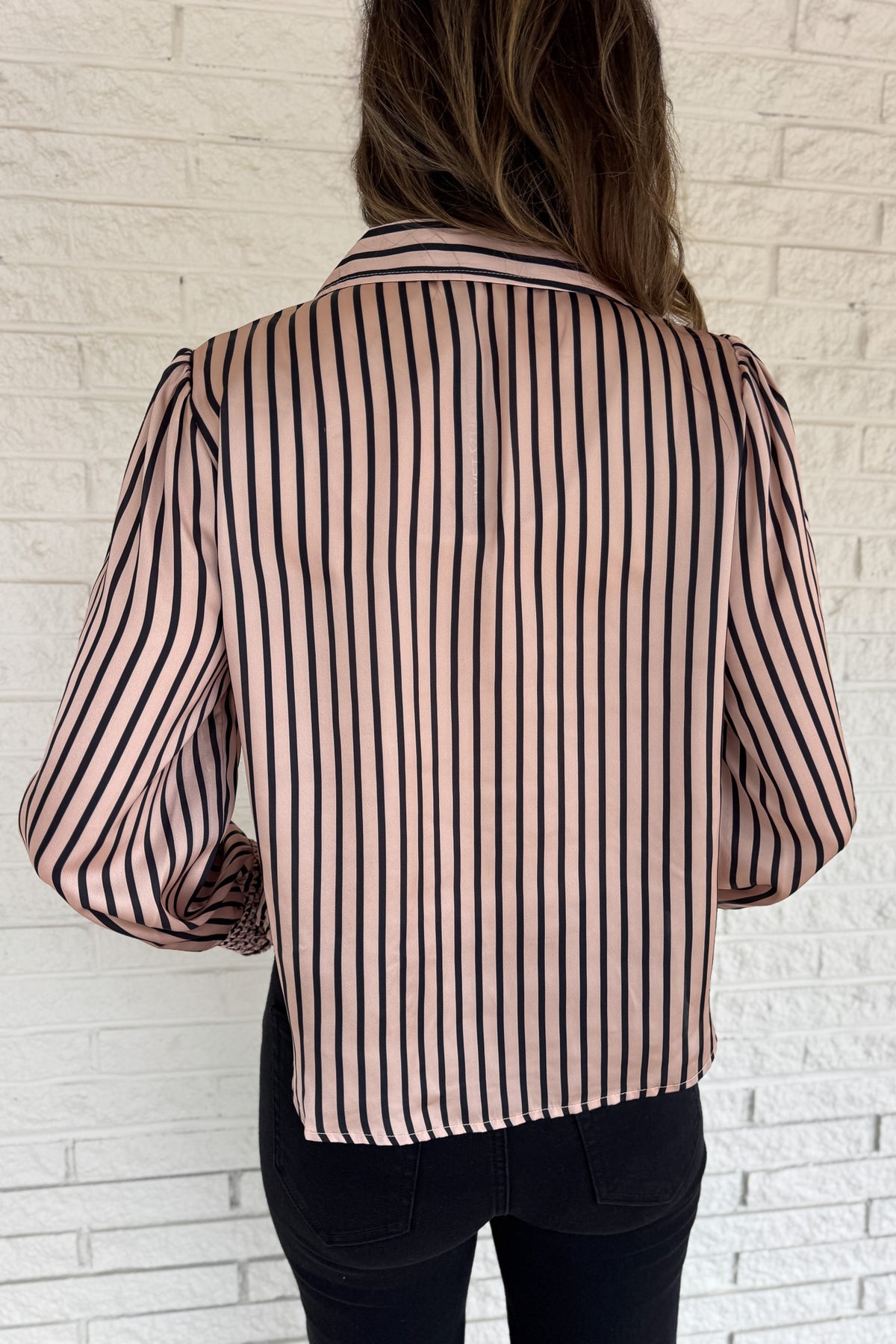 Soft satin with a polished drape, this striped top feels elevated yet easy. The relaxed silhouette and split neckline make it simple to style, while the vertical stripes elongate your frame. Smocked cuffs add a feminine finishing touch. Dress it up for work or keep it casual with denim.