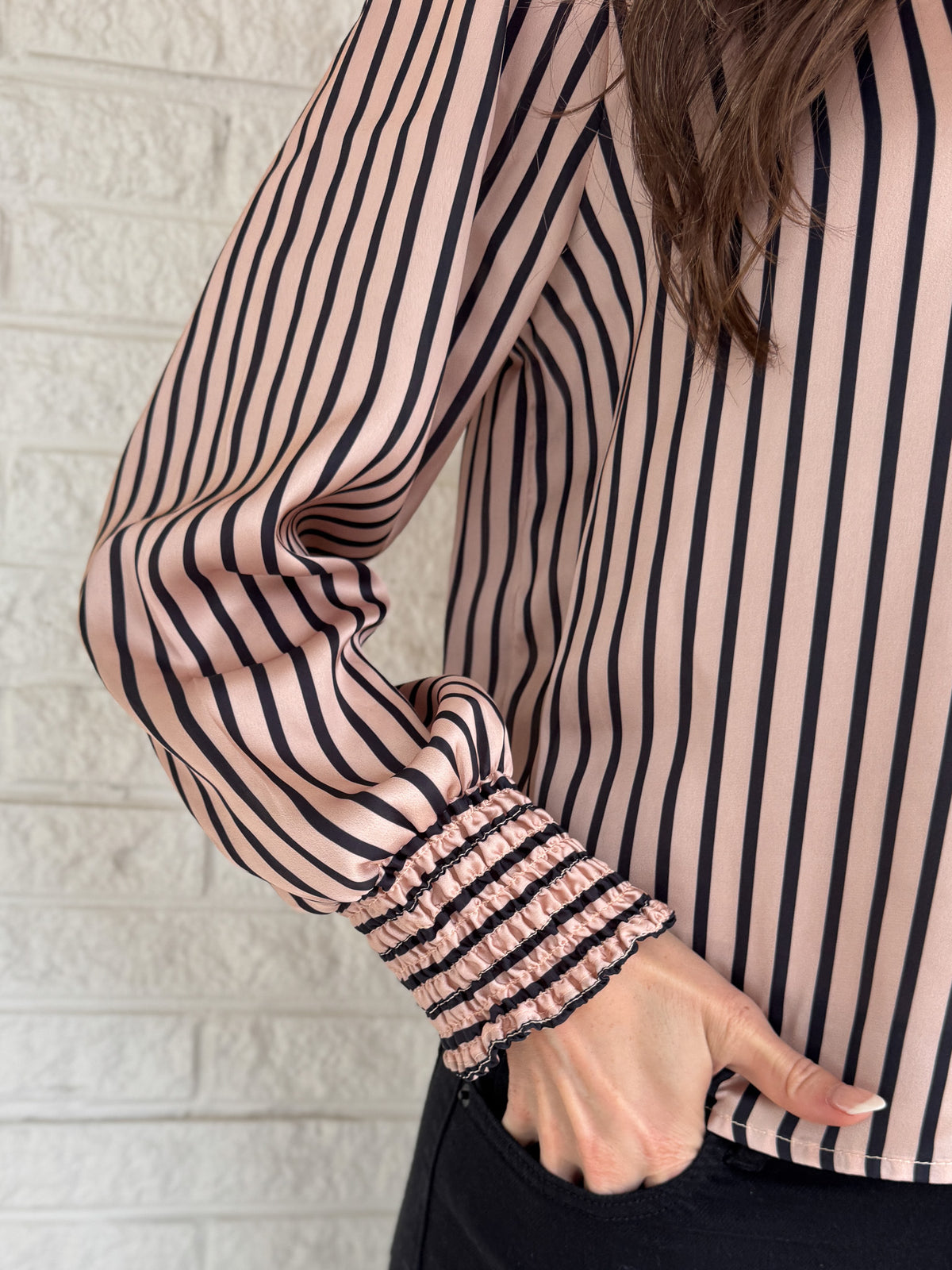Soft satin with a polished drape, this striped top feels elevated yet easy. The relaxed silhouette and split neckline make it simple to style, while the vertical stripes elongate your frame. Smocked cuffs add a feminine finishing touch. Dress it up for work or keep it casual with denim.