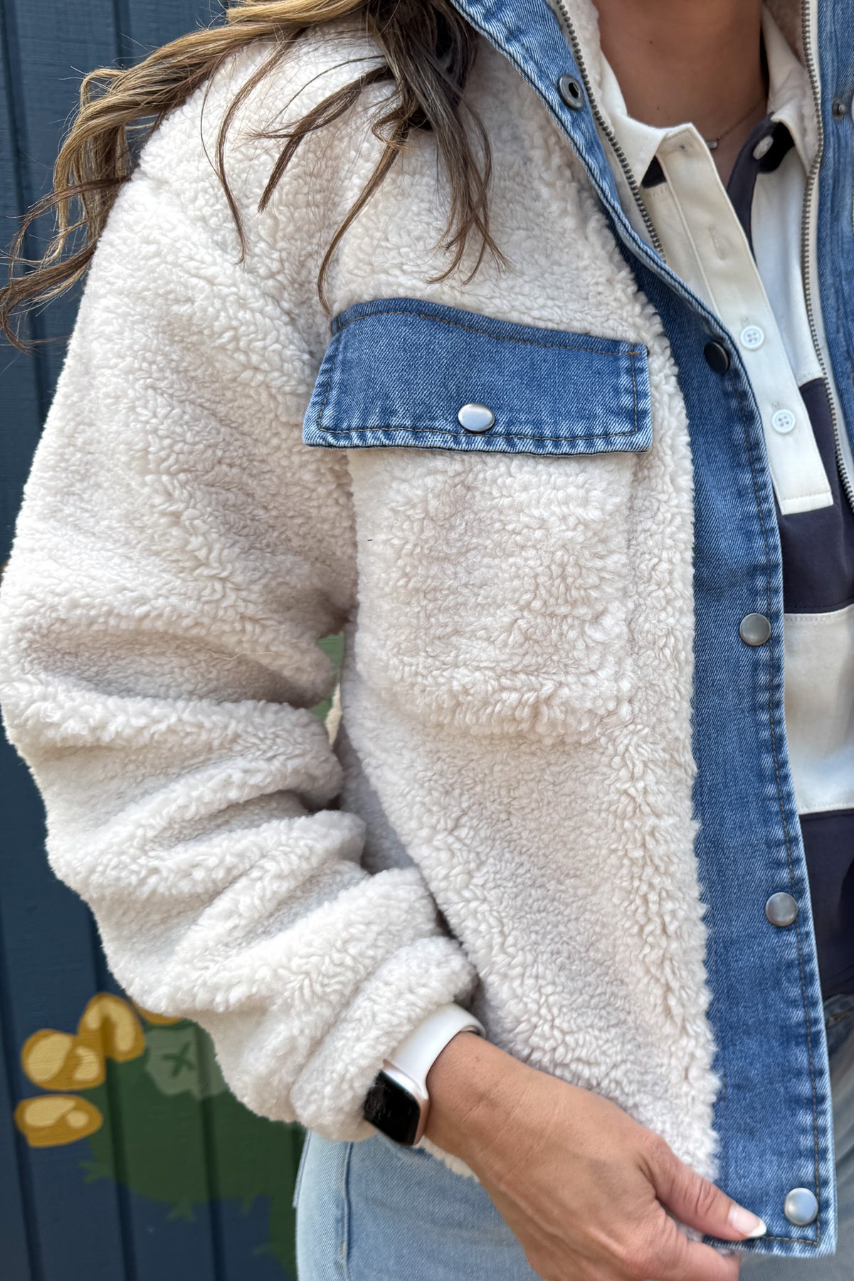 Cozy meets cool in this teddy bear jacket with denim trim. The soft, plush fabric keeps you warm and comfortable, while the cotton jersey lining adds an extra layer of softness. With snap-button chest pockets and a zip front, it’s both practical and stylish — an effortless layering piece for everyday wear.