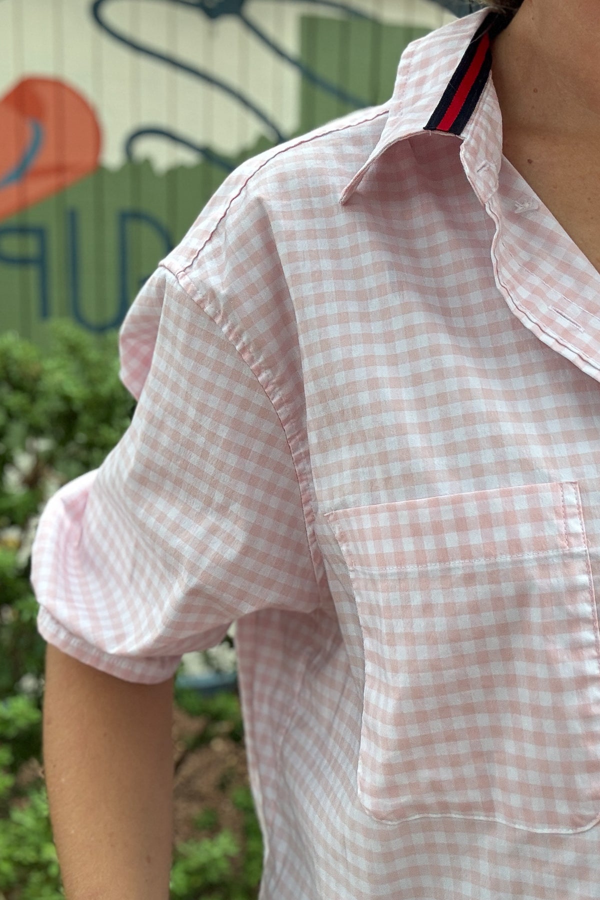 Back photo:
Back view of VonVie Harlow pink gingham cropped shirt with open back and red and navy ribbon ties

Side photo:
Side view of VonVie Harlow pink gingham shirt with puff sleeves, ruffled cuffs, and a relaxed cropped fit