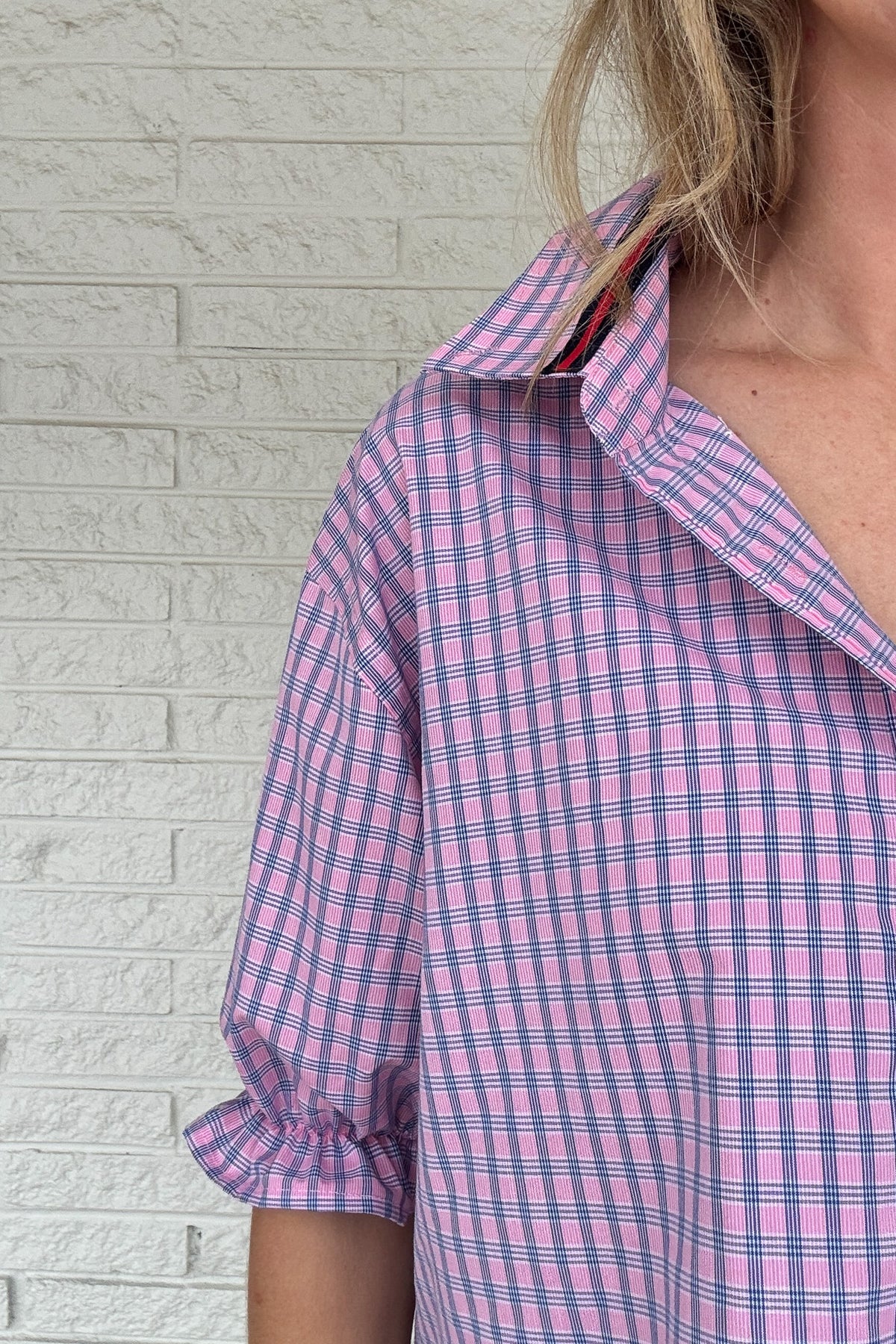 Front photo:
VonVie Harlow pink and blue plaid cropped button down shirt with puff sleeves and ruffled cuffs

Back photo:
Back view of VonVie Harlow pink and blue plaid shirt with open back and red and navy ribbon ties