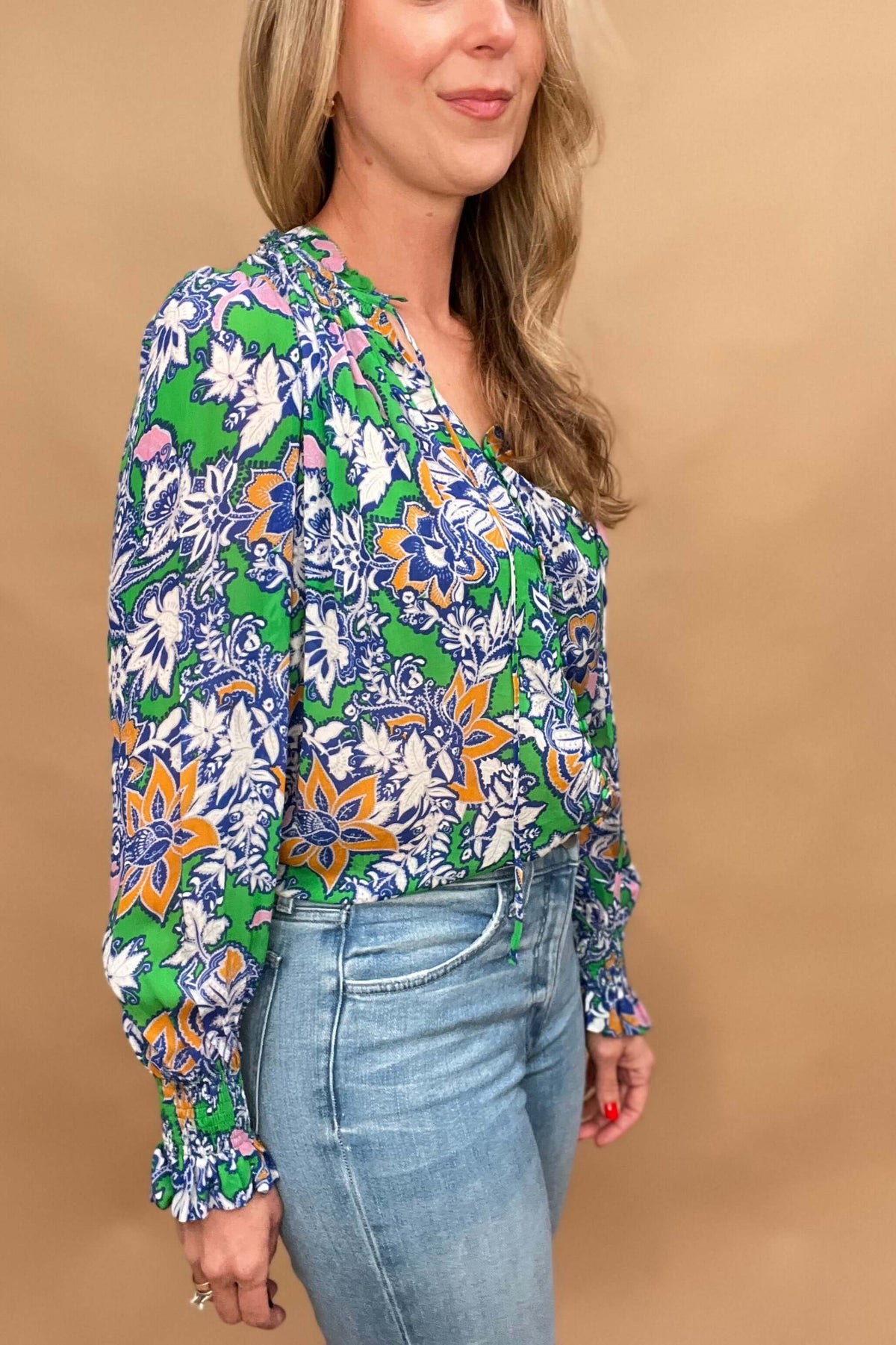 This lightweight and colorful fabric offers a playful twist with ruffled neckline and cuffs, tied neckline, and ever so slightly puffed shoulders.

The lightweight material is perfect for warmer days.&nbsp;

The fabric covered buttons, ruched detailing on the neckline &amp; cuffs adds an extra touch of elegance.