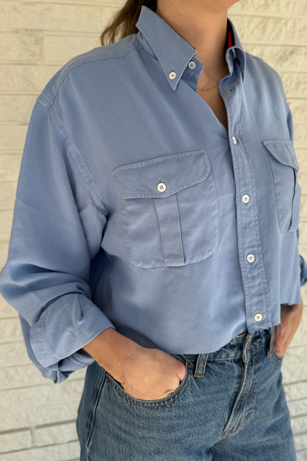 An upcycled men’s shirt reworked into a cropped, raw hem, easy silhouette that feels fresh and relaxed. Large front pockets add a fun twist to the buttery soft shirt. Soft, breathable, and one-of-a-kind. Designed to be a one size fits most, wear it buttoned up and it fits like an XS or small, wear it open and it fits size medium or large.