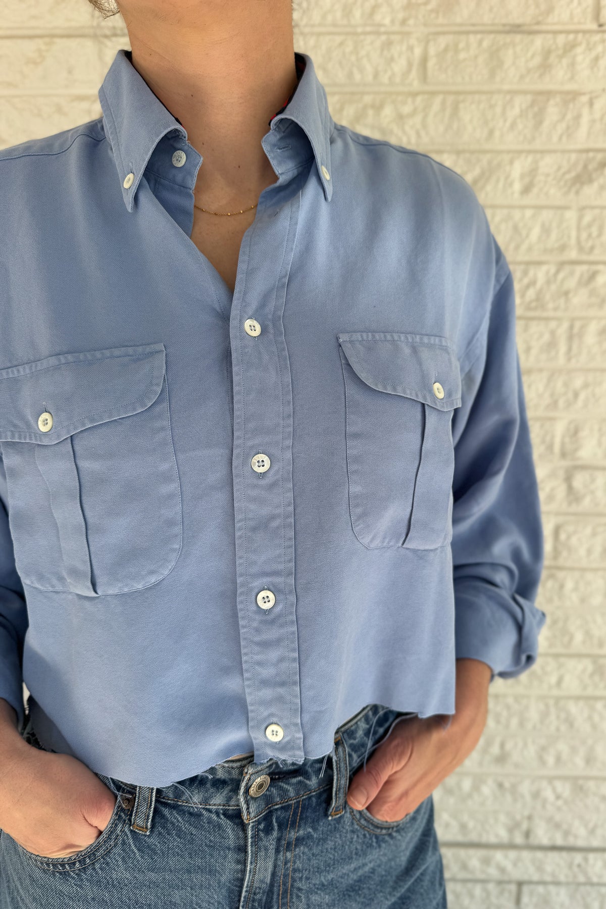 An upcycled men’s shirt reworked into a cropped, raw hem, easy silhouette that feels fresh and relaxed. Large front pockets add a fun twist to the buttery soft shirt. Soft, breathable, and one-of-a-kind. Designed to be a one size fits most, wear it buttoned up and it fits like an XS or small, wear it open and it fits size medium or large.