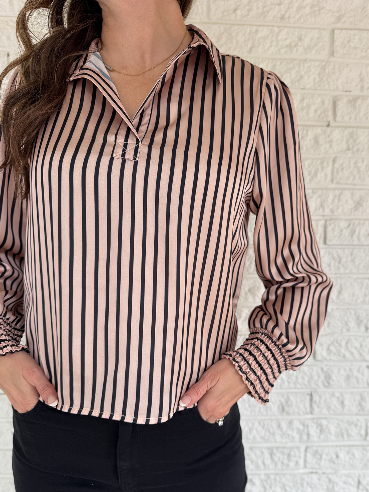 Soft satin with a polished drape, this striped top feels elevated yet easy. The relaxed silhouette and split neckline make it simple to style, while the vertical stripes elongate your frame. Smocked cuffs add a feminine finishing touch. Dress it up for work or keep it casual with denim.