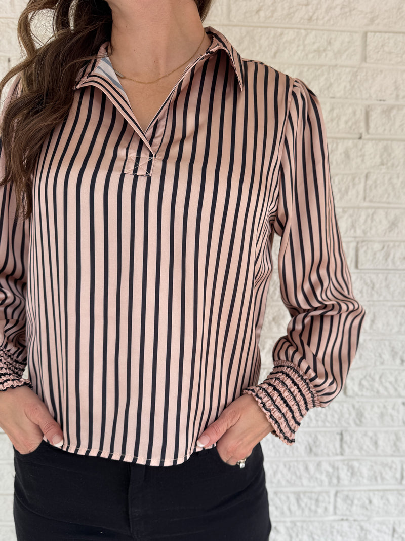 Soft satin with a polished drape, this striped top feels elevated yet easy. The relaxed silhouette and split neckline make it simple to style, while the vertical stripes elongate your frame. Smocked cuffs add a feminine finishing touch. Dress it up for work or keep it casual with denim.