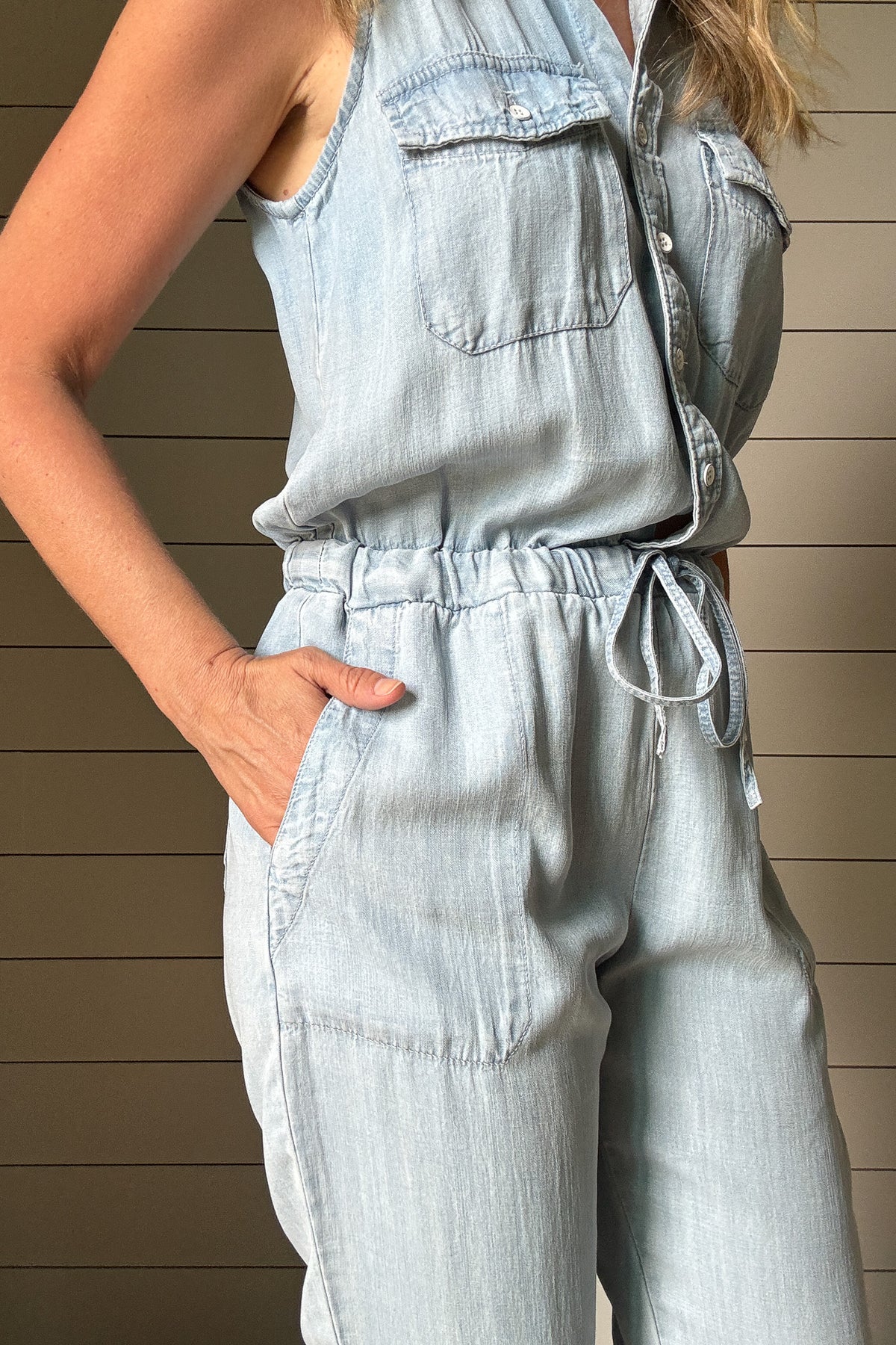 Meet your new go-to: the one-and-done Summer Jumper. Made from buttery soft, breathable Tencel fabric, this lightweight style keeps you cool and comfortable all day. The sleeveless design and button-front detail give it a laid-back vibe, while the drawstring waist adds shape without sacrificing ease. Chest pockets and relaxed-fit legs keep the look casual but pulled together—perfect for weekends, errands, or travel. Pair with sneakers or sandals and you're out the door in minutes. Made with sustainable fabr