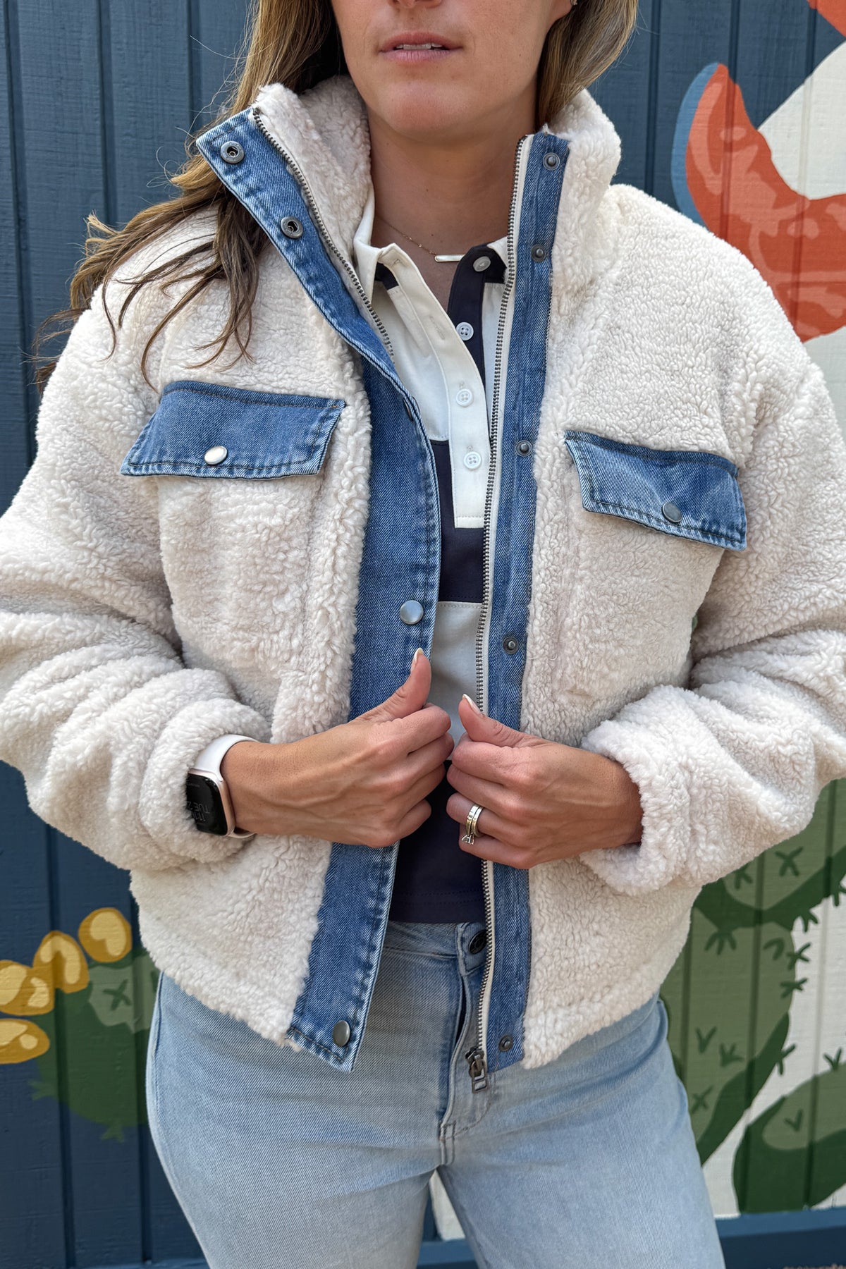 Cozy meets cool in this teddy bear jacket with denim trim. The soft, plush fabric keeps you warm and comfortable, while the cotton jersey lining adds an extra layer of softness. With snap-button chest pockets and a zip front, it’s both practical and stylish — an effortless layering piece for everyday wear.