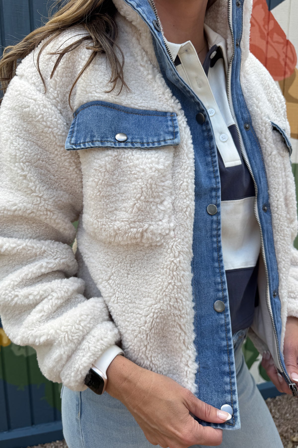 Cozy meets cool in this teddy bear jacket with denim trim. The soft, plush fabric keeps you warm and comfortable, while the cotton jersey lining adds an extra layer of softness. With snap-button chest pockets and a zip front, it’s both practical and stylish — an effortless layering piece for everyday wear.