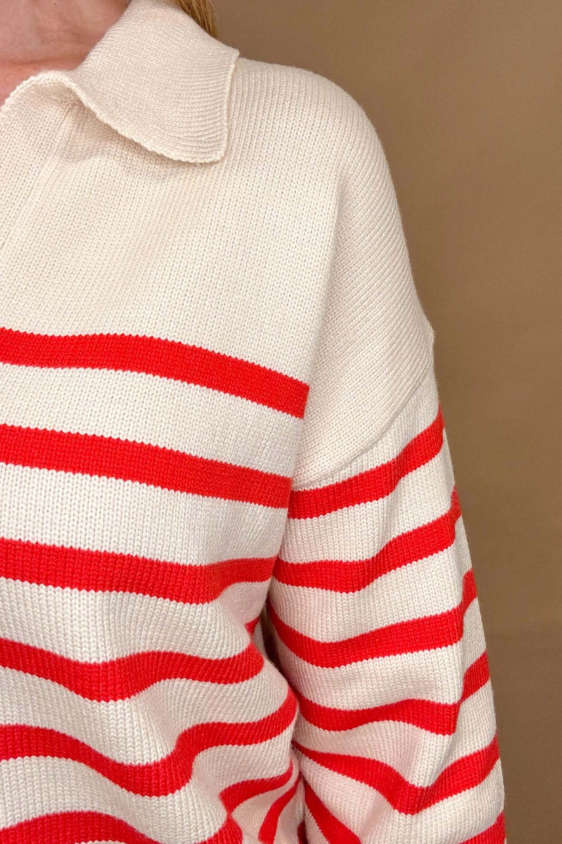 Effortlessly stylish, the Preppy Sweater in red and cream stripes is a must-have for any fashion-forward individual. Featuring a split neck with collar and hitting at the hip line, this sweater is perfect for a casual yet put-together look. Pair it with your favorite denim for an easy, on-the-go outfit.