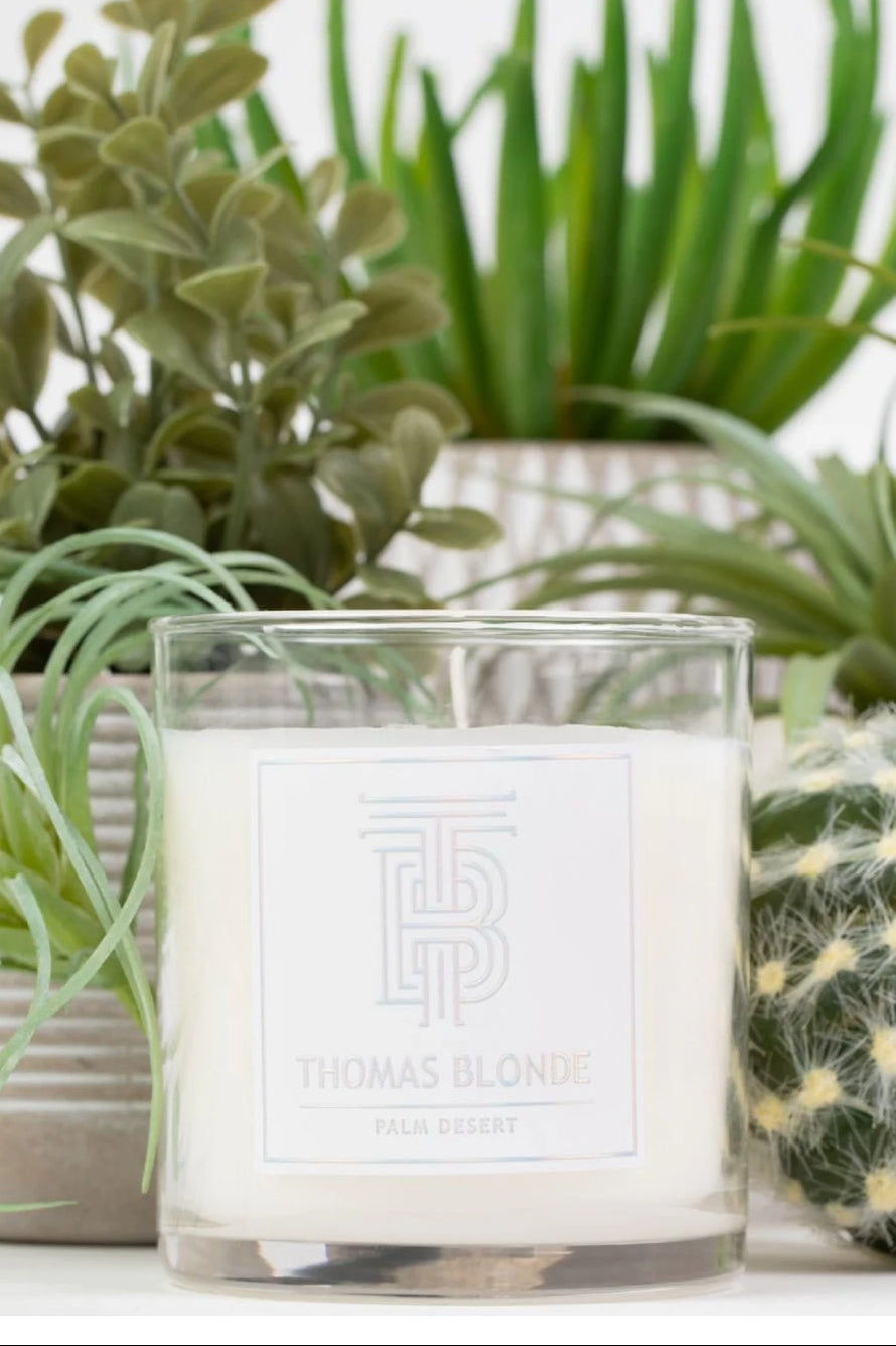 The Thomas Blonde Palm Desert Candle brings the warm, sun-kissed spirit of the desert into your home. With a sophisticated blend of sandalwood, amber, and citrus, this scent captures the feeling of golden sunsets and breezy palm trees. Hand-poured in small batches, each candle fills your space with a clean, lasting fragrance that feels both relaxed and refined.