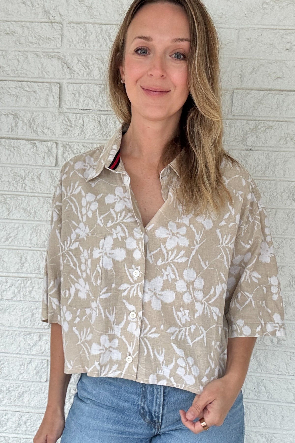 Front photo:
VonVie Harlow natural and white floral cropped button down shirt with relaxed elbow length sleeves

Back photo:
Back view of VonVie Harlow natural floral shirt with open back and red and navy ribbon ties