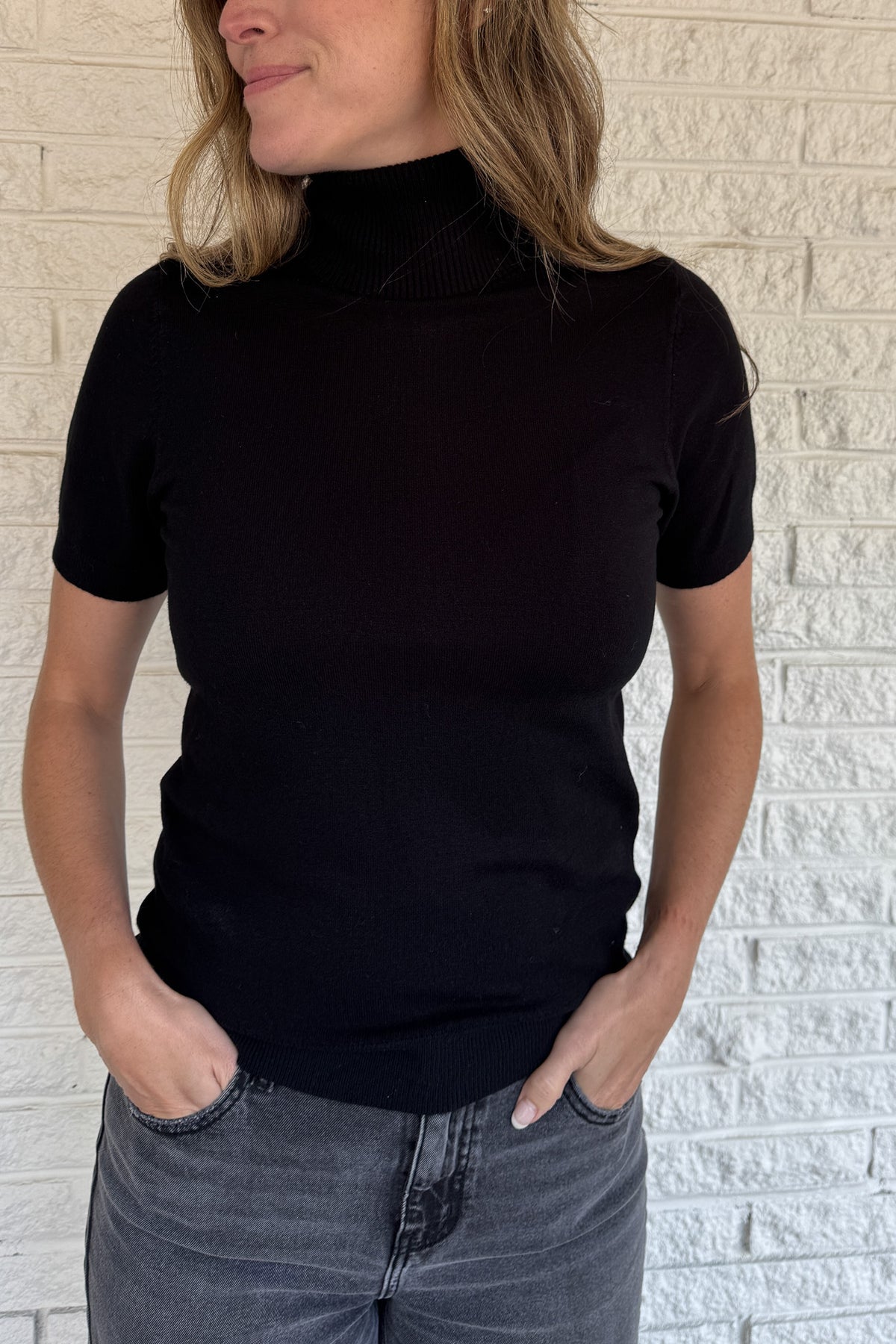 &nbsp;A modern twist on a classic silhouette, this short sleeve turtleneck sweater is sleek and versatile. The soft knit blend drapes comfortably while the fitted design makes it perfect for layering or wearing solo.