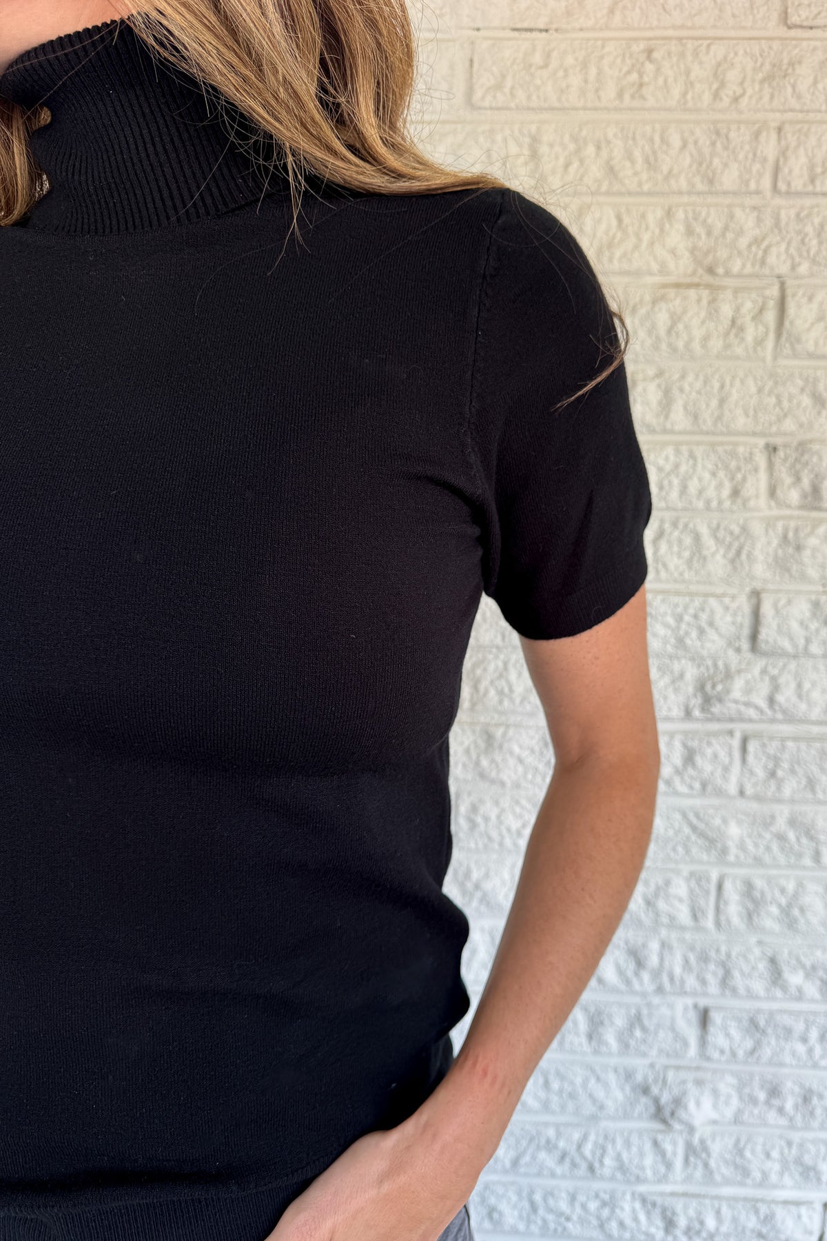 &nbsp;A modern twist on a classic silhouette, this short sleeve turtleneck sweater is sleek and versatile. The soft knit blend drapes comfortably while the fitted design makes it perfect for layering or wearing solo.