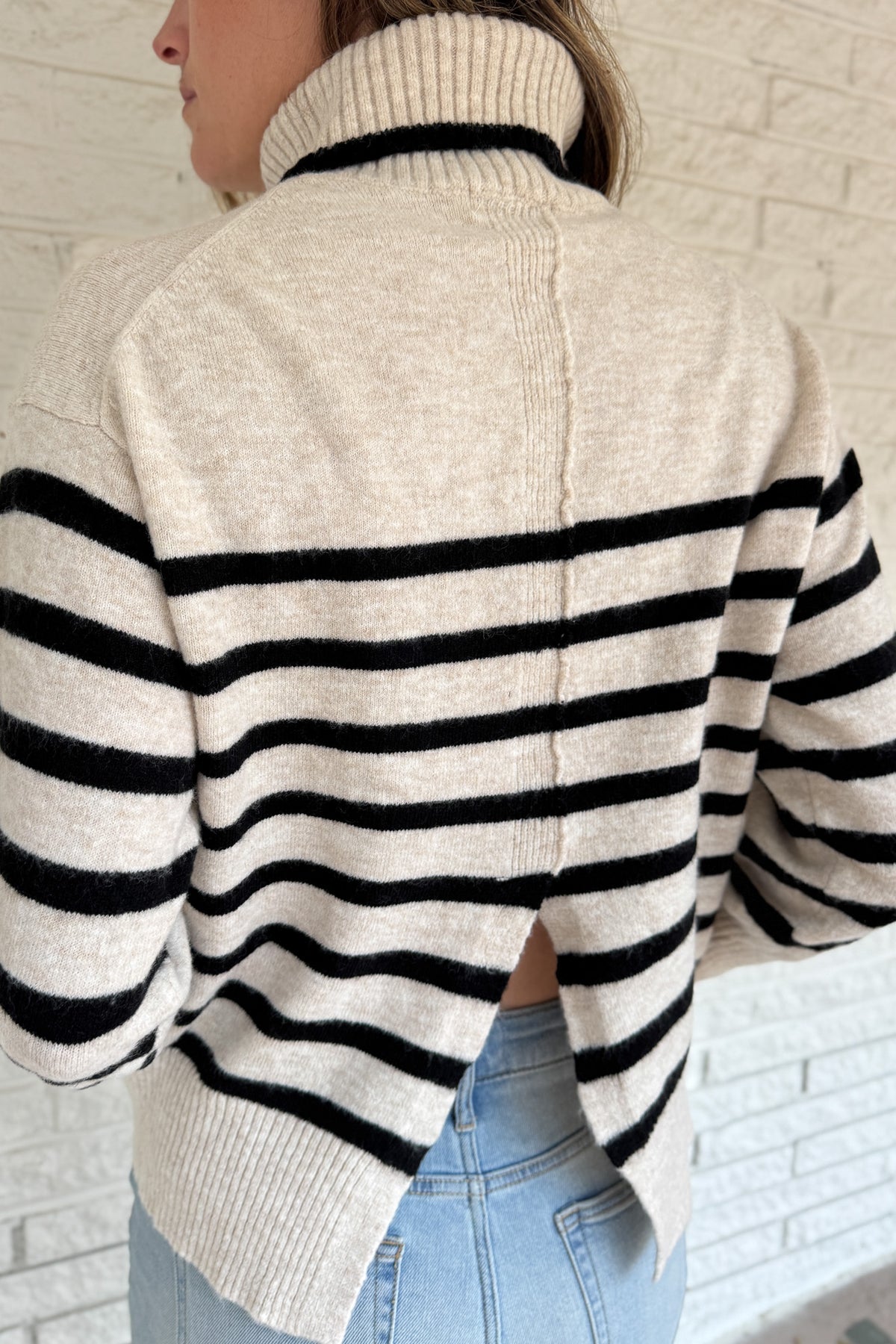 A modern take on the classic striped sweater, this cozy turtleneck features a chic open-back detail for an unexpected twist. Soft and warm with a relaxed fit, it’s an easy statement piece that pairs perfectly with denim or trousers for effortless style.