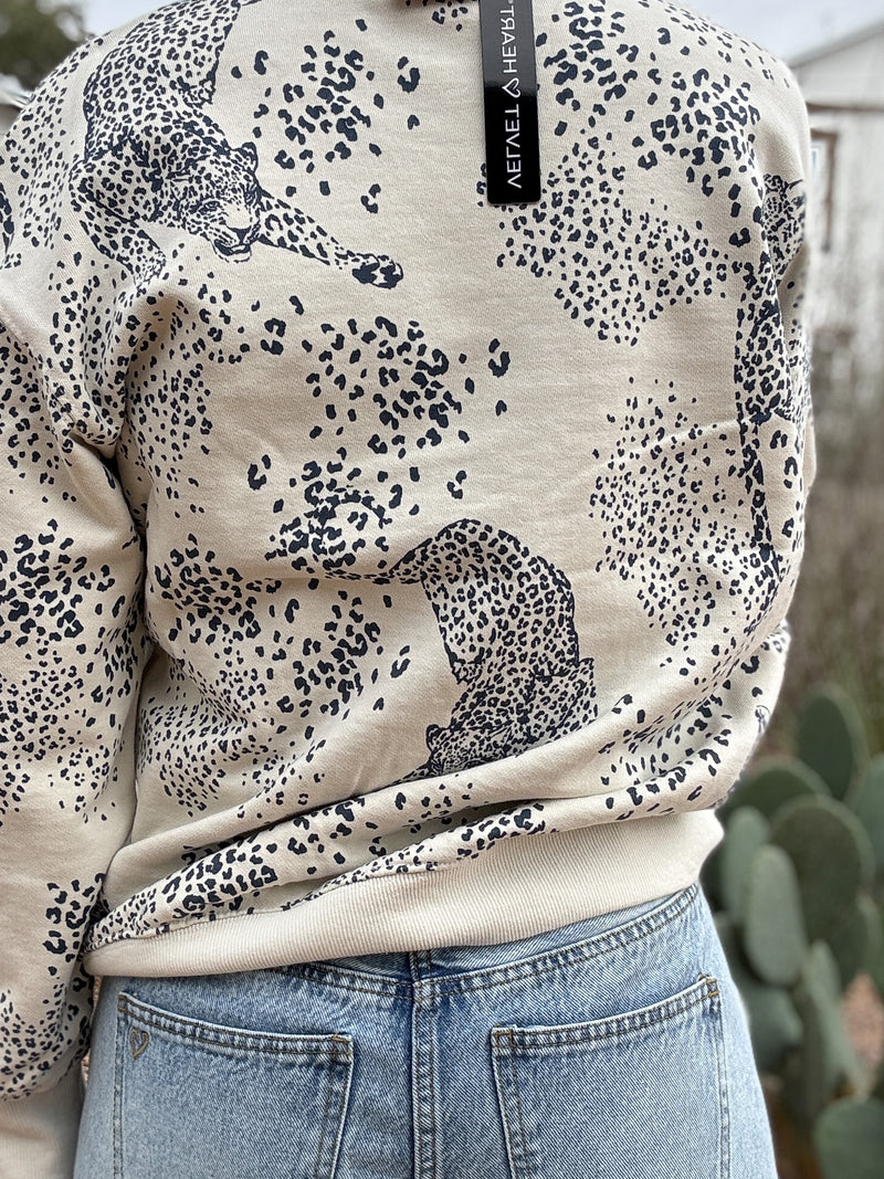 This cream sweatshirt features a soft neutral base with a subtle leopard print and cheetah motif throughout. Easy, relaxed, and made for everyday wear, it’s the kind of piece you’ll reach for on repeat. Perfect with denim, joggers, or layered under a jacket for effortless style. Women's fashion boutique Blanco Texas Johnson City Texas