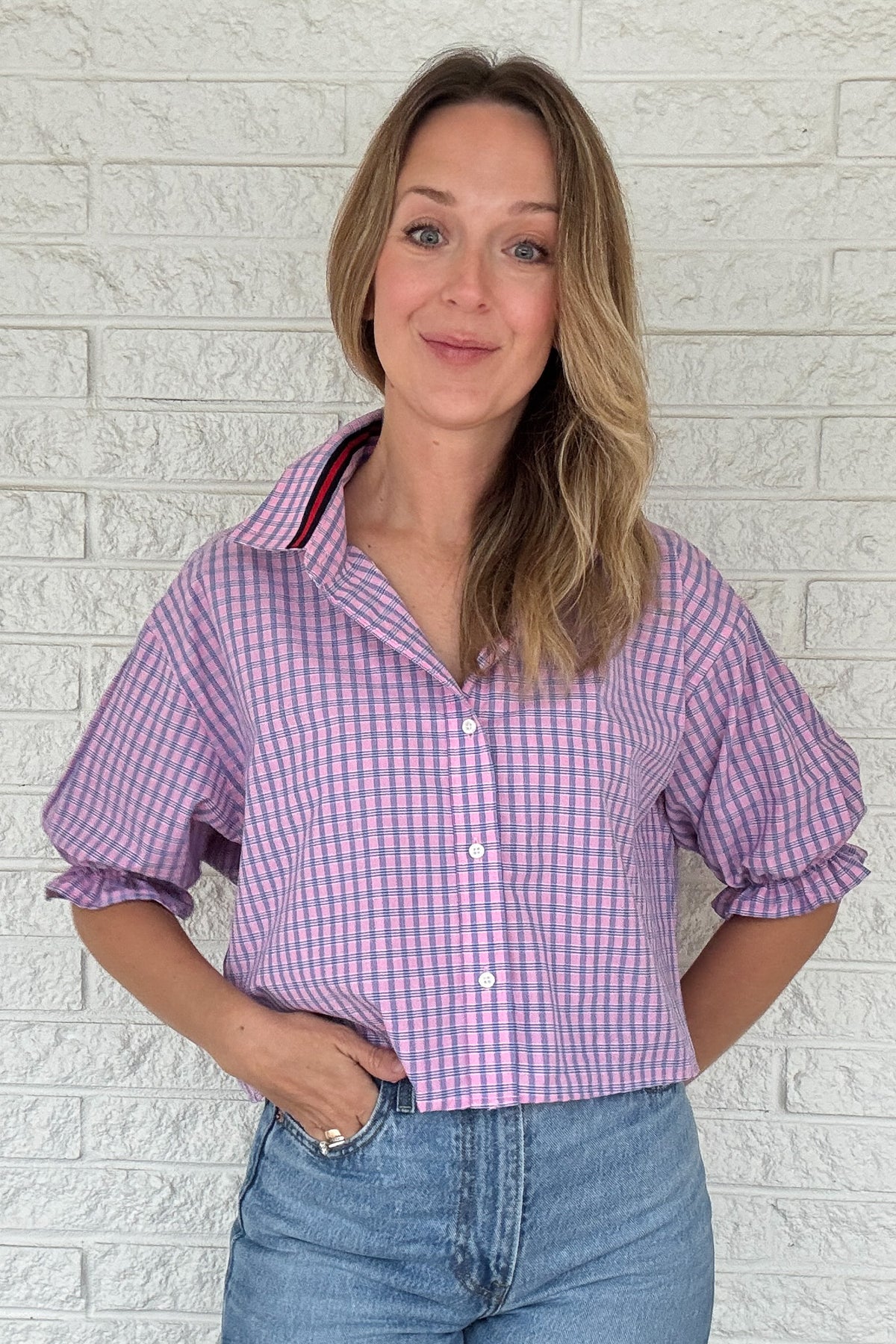 Front photo:
VonVie Harlow pink and blue plaid cropped button down shirt with puff sleeves and ruffled cuffs

Back photo:
Back view of VonVie Harlow pink and blue plaid shirt with open back and red and navy ribbon ties