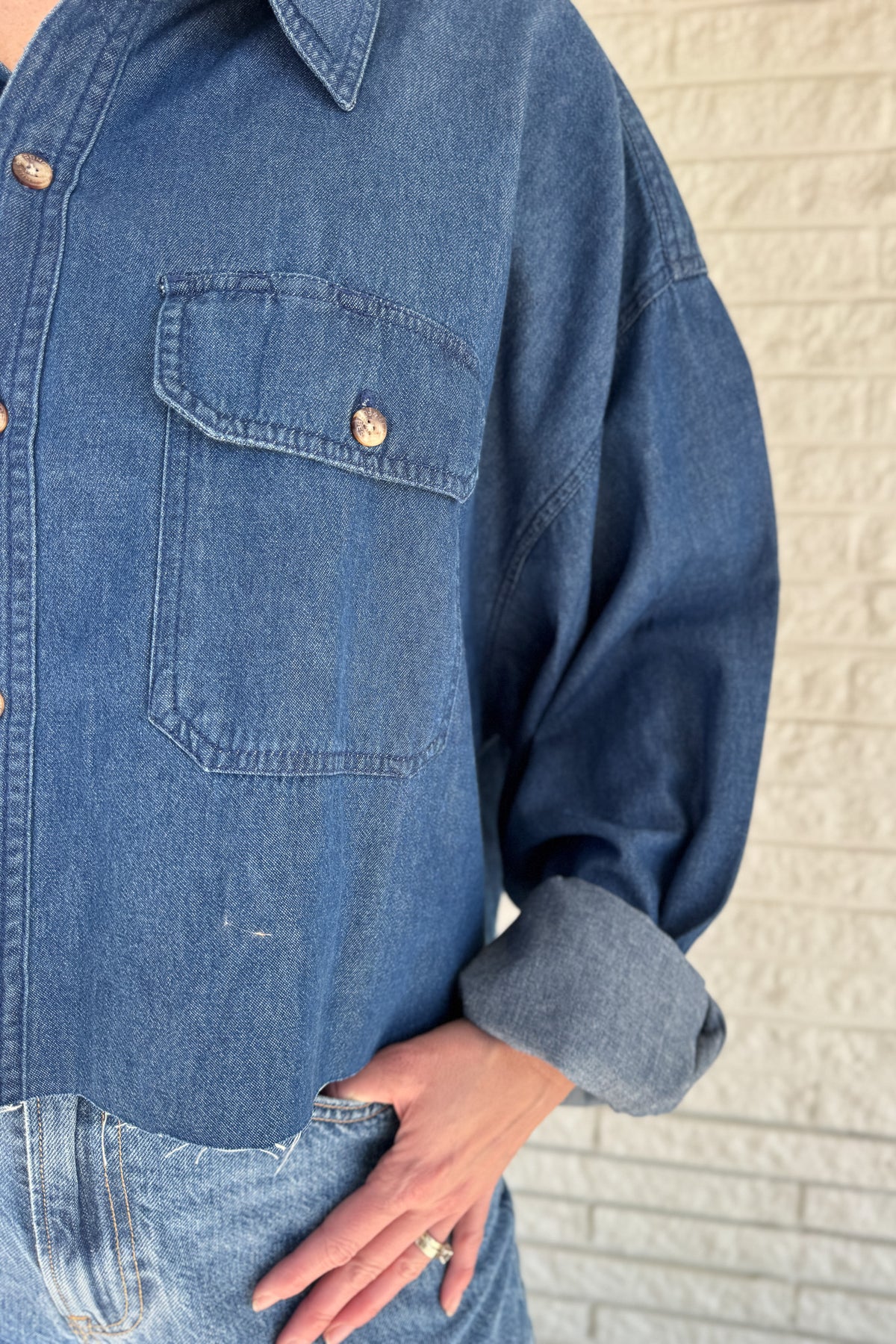 An upcycled men’s shirt reworked into a cropped, raw hem, easy silhouette that feels fresh and relaxed. Soft, classic, and one-of-a-kind. Designed to be a one size fits most, wear it buttoned up and it fits like medium or large.
