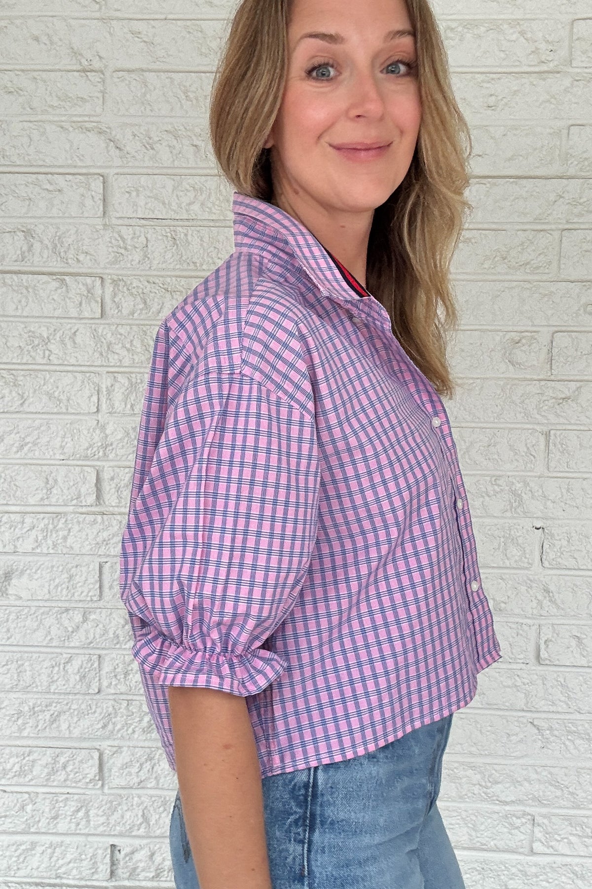 Front photo:
VonVie Harlow pink and blue plaid cropped button down shirt with puff sleeves and ruffled cuffs

Back photo:
Back view of VonVie Harlow pink and blue plaid shirt with open back and red and navy ribbon ties
