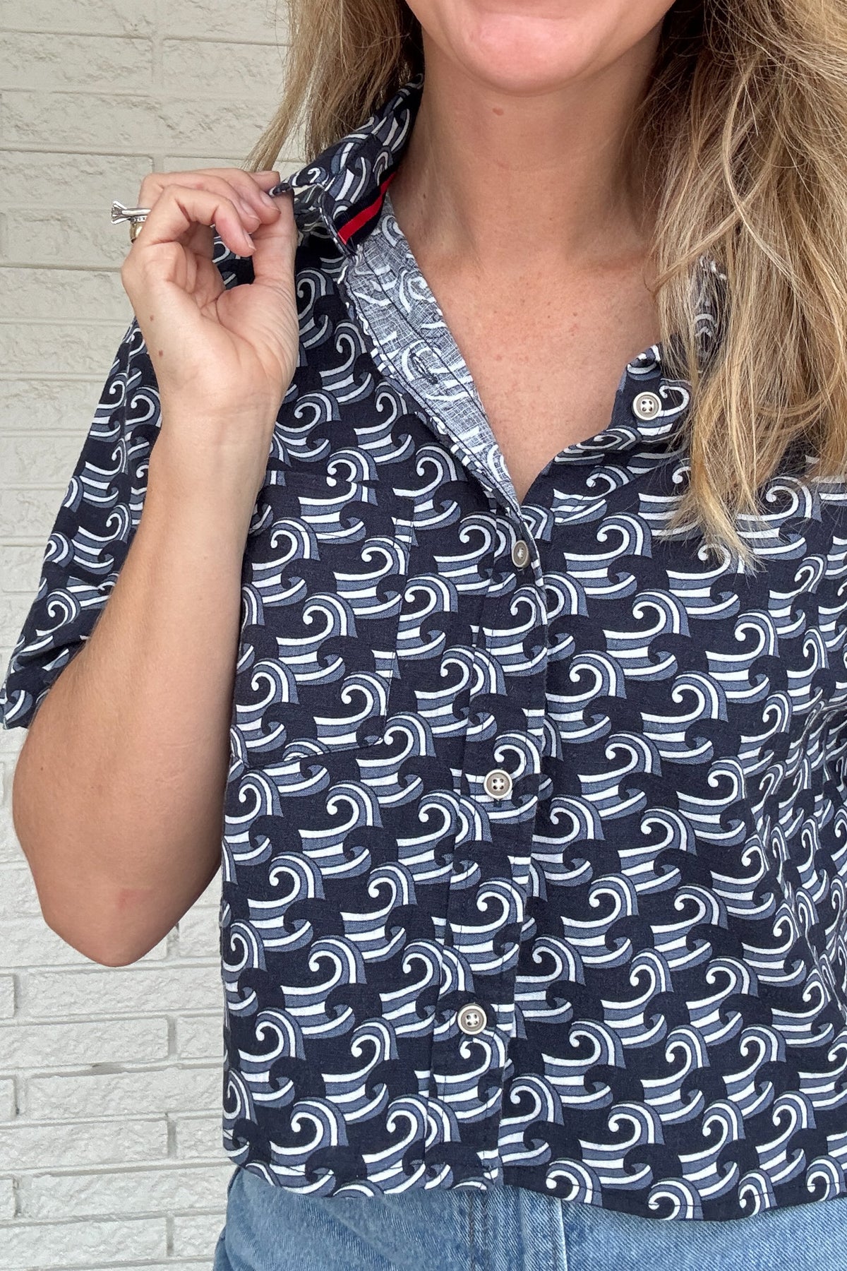 Front photo:
VonVie Harlow navy and white wave print cropped button down shirt with relaxed elbow length sleeves

Back photo:
Back view of VonVie Harlow navy wave print shirt with open back and red and navy ribbon ties