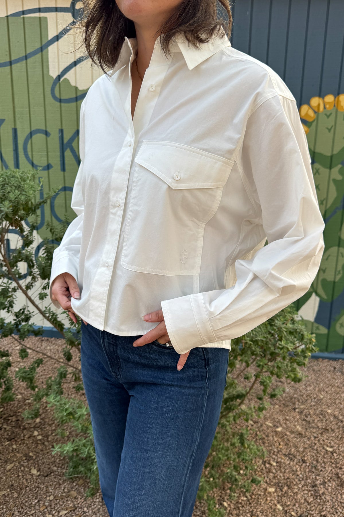 Women’s white 100% cotton button down shirt with oversized chest pocket, relaxed fit, and wide cuffs.