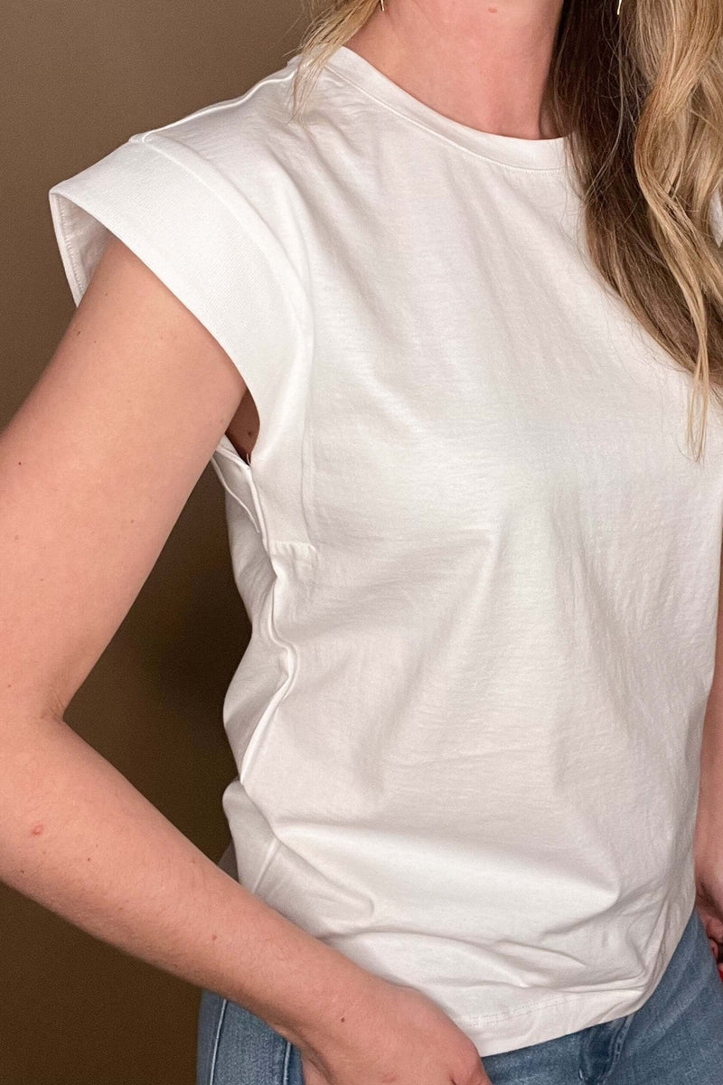 Elevate your wardrobe with our White Shoulder Detail Tee! This closet staple is made from 100% cotton, offering both comfort and style. The shoulder detailing adds a unique touch to this classic white tee. Perfect for layering or pairing with denim cut offs for a timeless warm weather look.