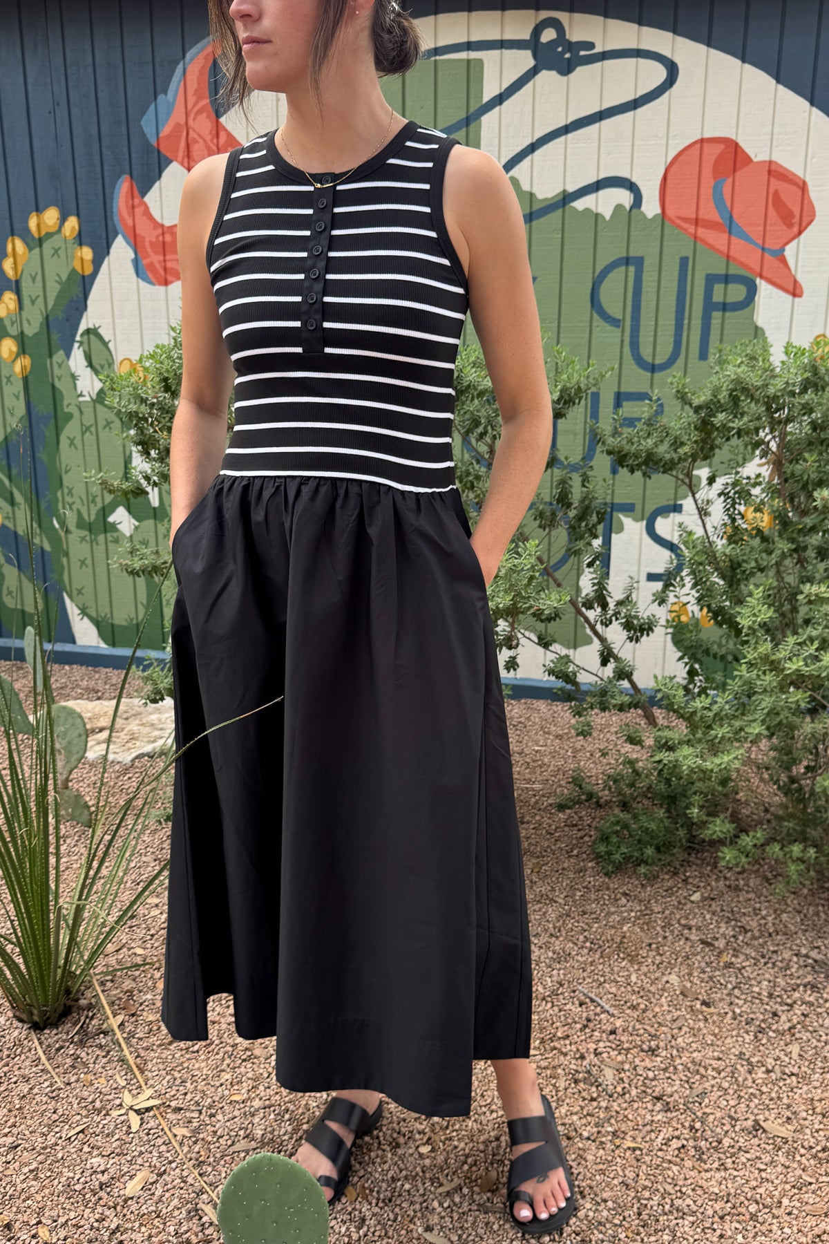 Women’s sleeveless black midi dress with a striped fitted bodice, button front, gathered skirt and functional side pockets.