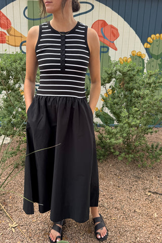 Women’s black midi dress with a fitted black and white striped ribbed bodice, button front, sleeveless cut and gathered full skirt with pockets.