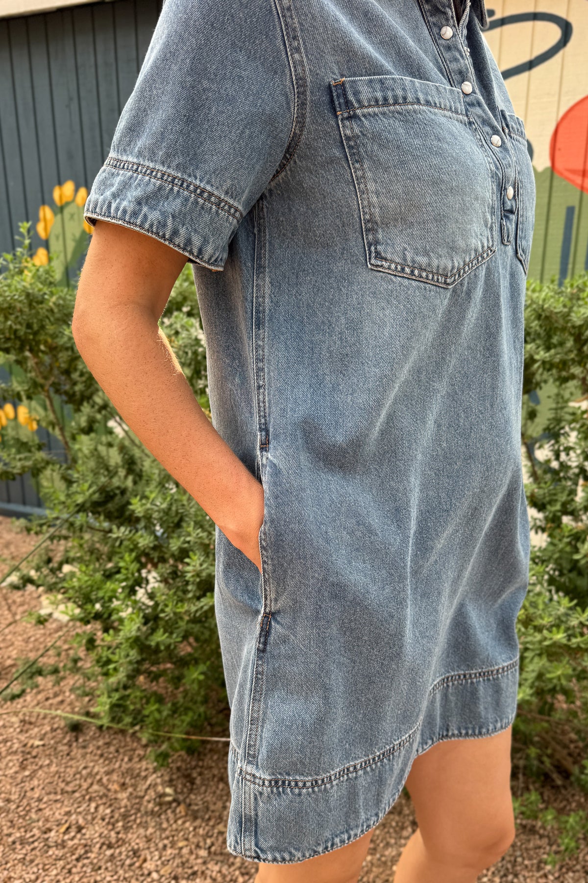 Women’s light wash denim shirt dress with short sleeves, pearl snap front, chest pockets and side pockets at Cotton & Cashmere in Blanco, Texas.