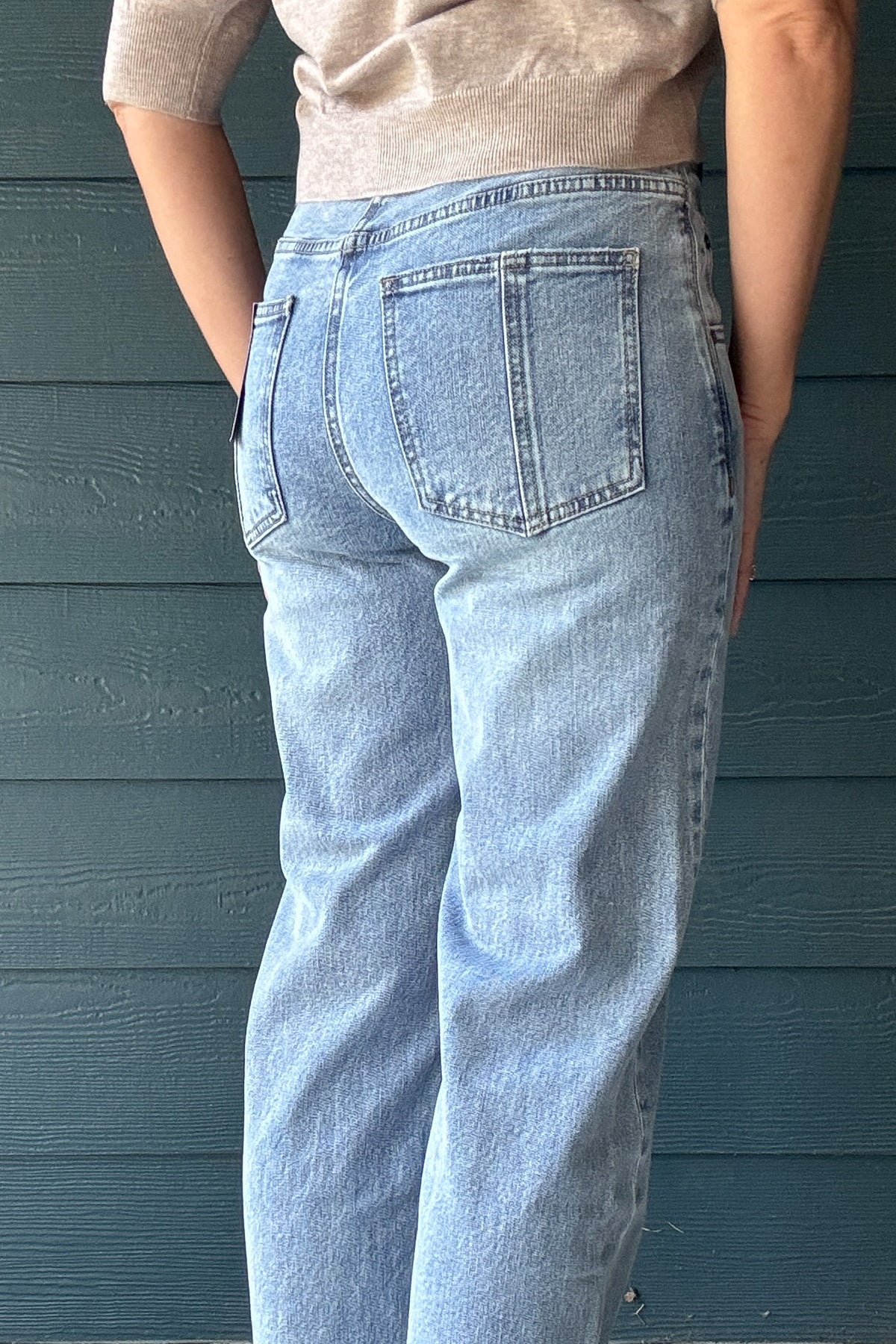 Back view of women’s light wash high-rise wide-leg jeans with classic patch pockets and a relaxed fit through the leg.