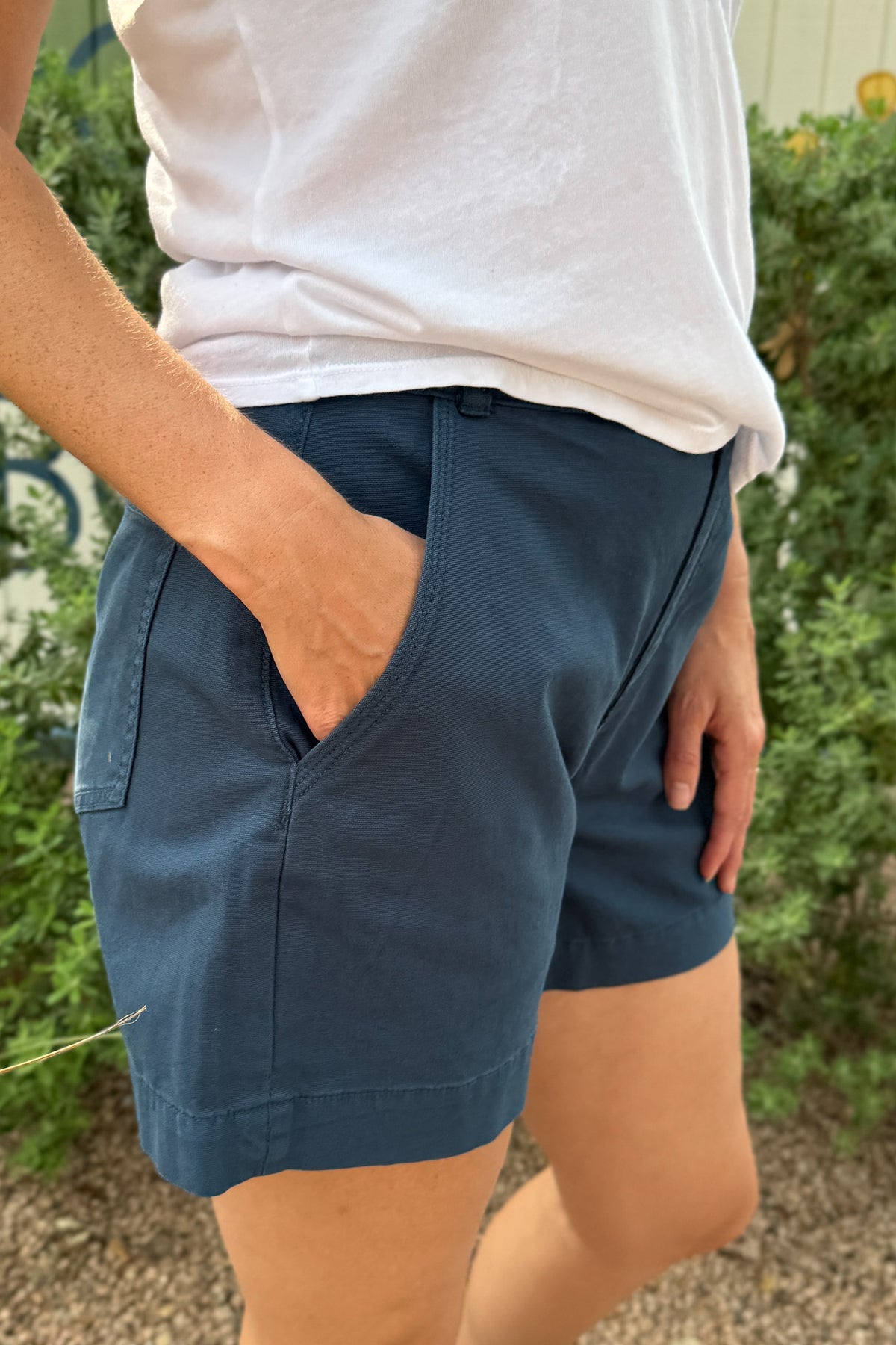 Close-up of women’s navy blue casual shorts with a mid-rise fit, front pockets and a clean tailored hem.