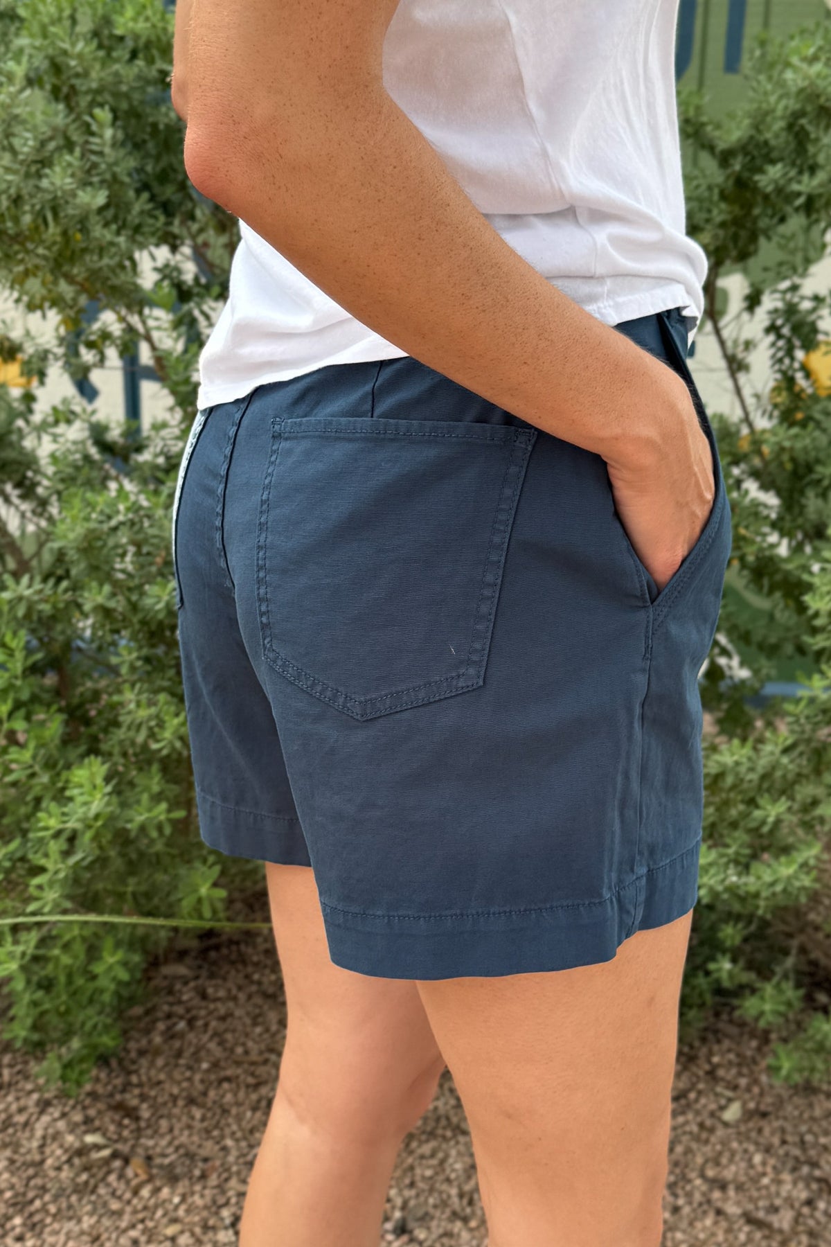 Back and side view of women’s navy blue shorts featuring functional patch pockets, side pockets and an easy everyday fit.