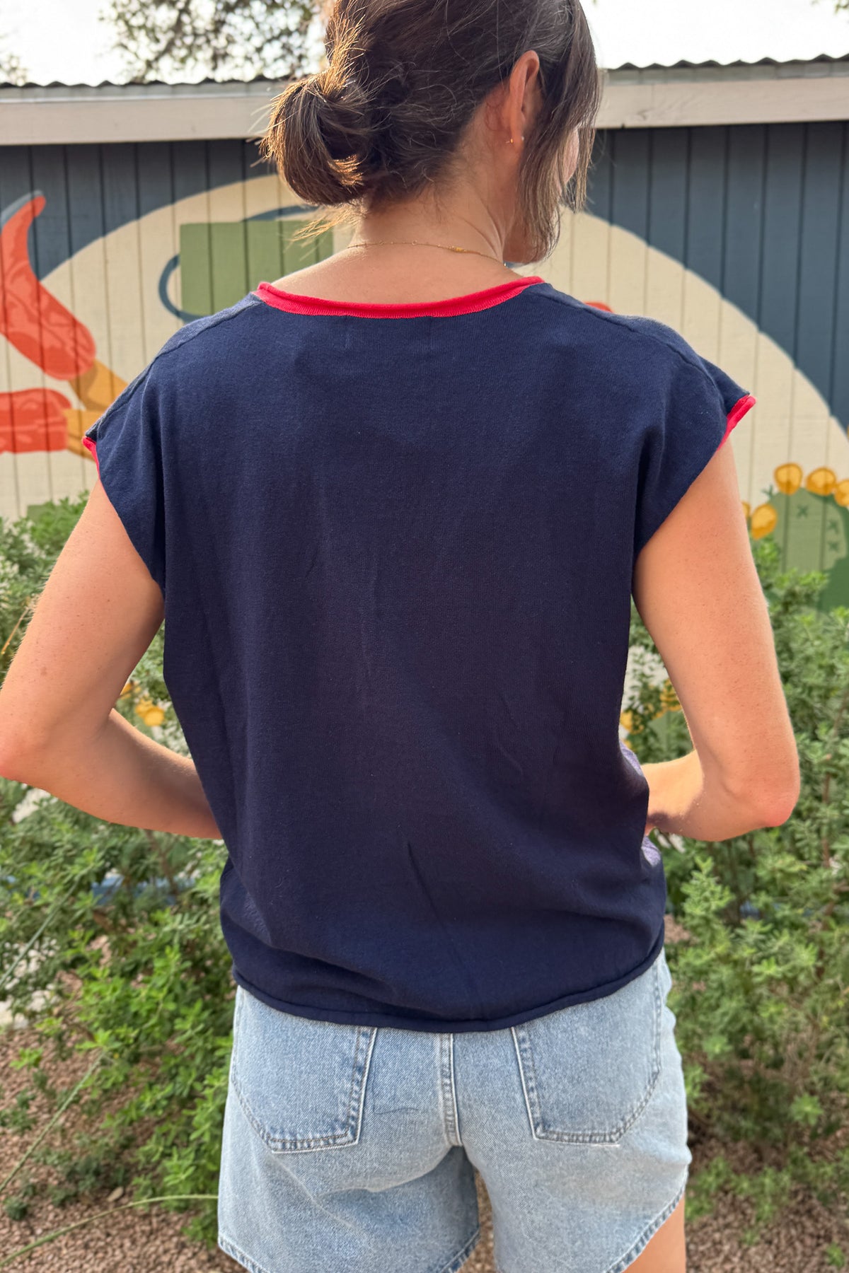 Back view of a women’s navy relaxed-fit top with red contrast trim, cap sleeves and an easy hip-length silhouette.