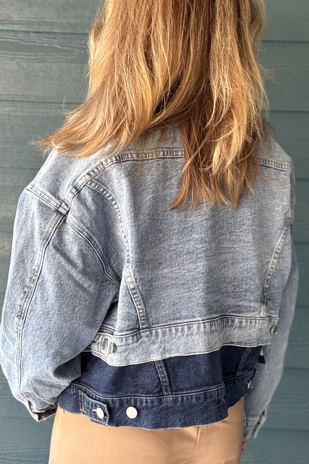 Women’s two-tone jean jacket with oversized fit, button front, chest pockets and contrasting light and dark denim washes.