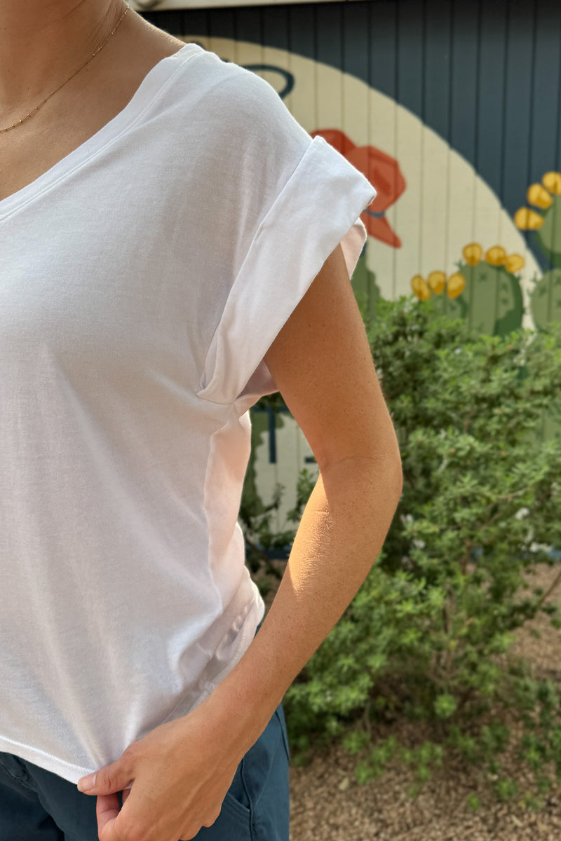 Close-up of a women’s white V-neck tee featuring wide rolled cap sleeves, soft lightweight fabric and a relaxed everyday fit.